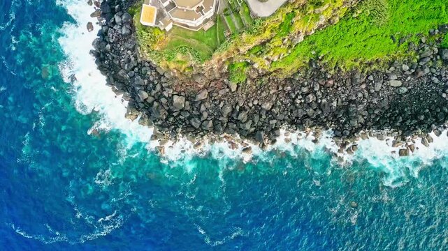 Topdown view of Arnel Lighthouse on turquoise seashore cliff in S&atilde;o Miguel Island, Azores