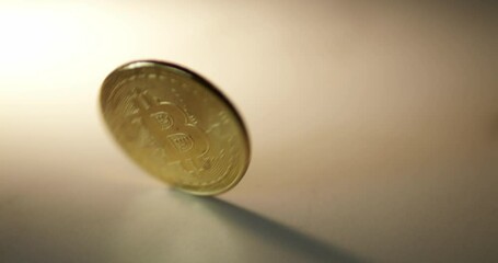 A piece of commemorative golden coin in Thai Baht currency is twirling and slowing down as it lays down on a table.