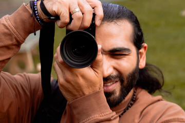 Long-haired, bearded Latino man in a brown jacket documenting his holiday and enjoying the golden hour in his country. World photography and travel day.