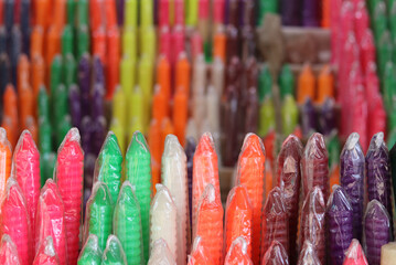 Multi-coloured candles placed in a shop for sale.