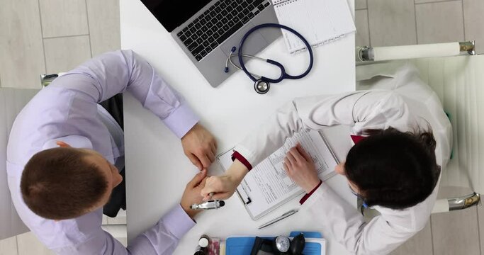 Doctor uses reflex hammer testing patient reflexes in clinic