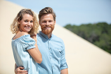 beautiful young couple relaxing hugging on beach dune