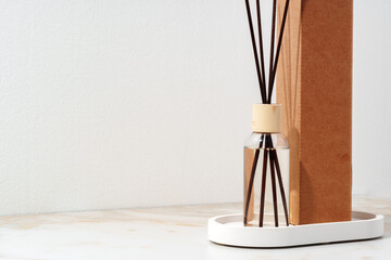 Reed Diffuser Bottle With Wooden Sticks on White Tabletop