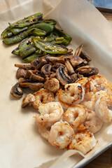 A view of roasted ingredients for shrimp fajitas, featuring mushrooms and jalapenos.