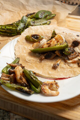 A view of shrimp mushroom fajitas in a corn tortilla.