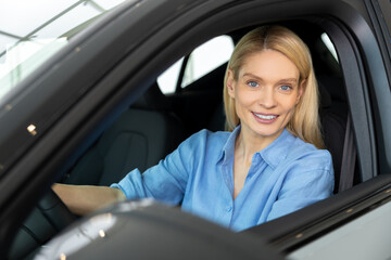 Waist up of a smiling woman sitting in a car