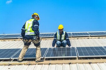 Worker Technicians are working to construct solar panels system on roof with sky and clound on background. Installing solar photovoltaic panel system. Renewable clean energy technology concept.