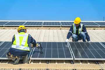 Worker Technicians are working to construct solar panels system on roof with sky and clound on background. Installing solar photovoltaic panel system. Renewable clean energy technology concept.