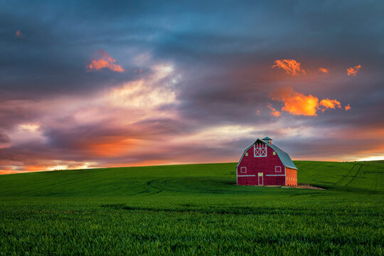 Dramatic sunset over a red barn in the Palouse in eastern Washington state