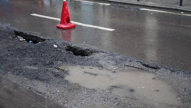 Big pot hole filled with water at street