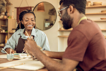 Dark-skinned young woman participating in a pottery workshop