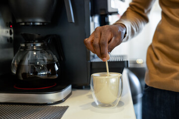 Man office worker brewing coffee beverage using coffeemaker during break at work