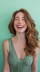 Naklejka premium A woman with long, brown hair laughs with her eyes closed