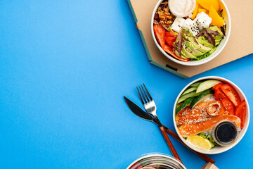 Different poke bowls on blue background top view