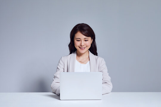 スーツを着た女性とノートパソコン