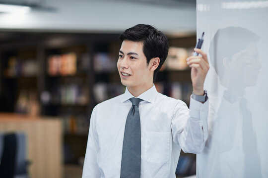 ホワイトボードを使い会議をするビジネスマン