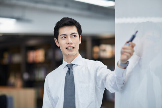 ホワイトボードを使い会議をするビジネスマン