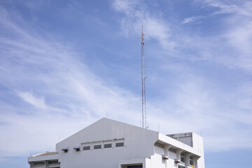 Telephone poles installed on the office building for communicating in the blue sky.