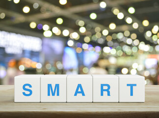 Smart letter on white block cubes on wooden table over blur light and shadow of shopping mall, Business success concept