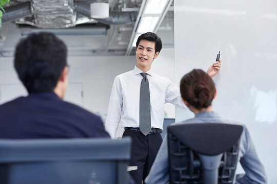 ホワイトボードを使い会議をするビジネスマン