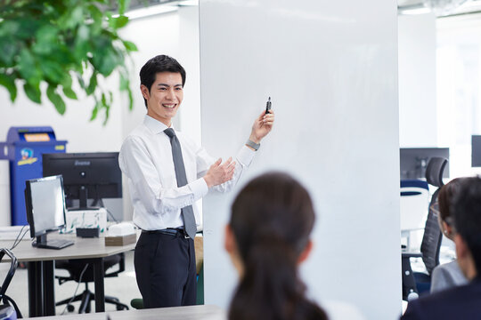 ホワイトボードを使い会議をするビジネスマン