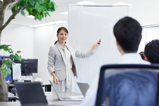 ホワイトボードを使い会議をするビジネスウーマン