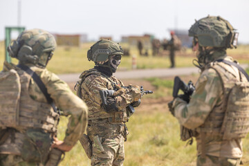 Fototapeta premium Army soldier with a machine gun in his hand. Soldier, commando stands, ready for combat training. Military fashion. Army attack enemy soldier in military uniform.