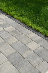 Brick pavement cobblestone footpath with grass lawn