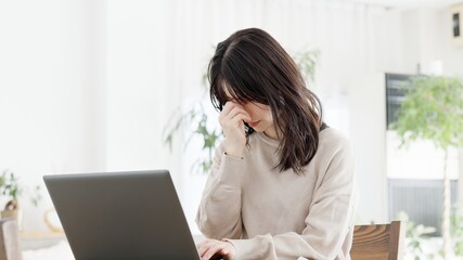 パソコン作業に目の疲れを感じる女性