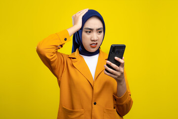 Upset young Asian woman looking at mobile phone screen with worried expression, reading negative...