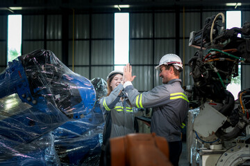 team engineers inspecting on machine with smart tablet. Worker works at heavy machine robot arm. The welding machine with a remote system in an industrial factory. Artificial intelligence concept.