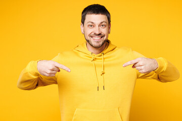 Young happy smiling shocked cheerful surprised Caucasian man he wears hoody casual clothes point...