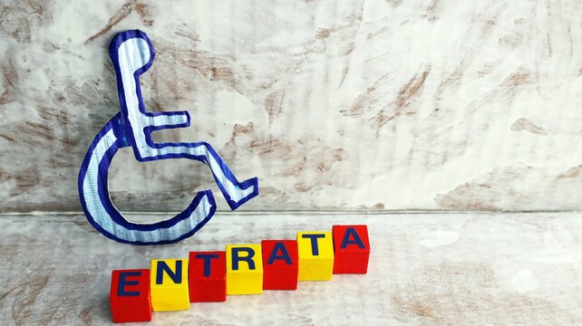 Disabilit&agrave; segnaletica di accessibilit&agrave; per persone con mobilit&agrave; ridotta vicino all'ingresso di un edificio pubblico in Italia.