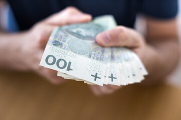 Osoba trzymając w dłoni banknoty. Biznes i finanse. 