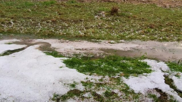 Hail from a severe thunderstorm forms large piles in a ditch near Enders Nebraska