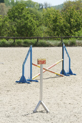  Horse obstacle course outdoors summertime. Poles in the sand for equestrian event