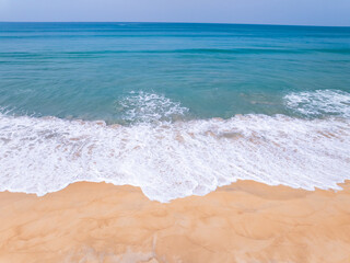 Top view beach with waves crashing on sandy shore,Beautiful waves sea surface in summer seascape background,Amazing beach colorful water background