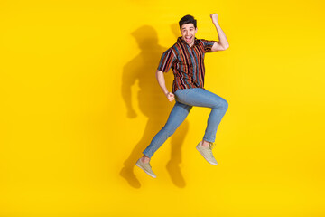 Full size photo of nice young man jump empty space wear shirt isolated on yellow color background