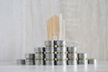 Mortgage,Model house and stack of coins money on wooden background,Business investment and real estate concept