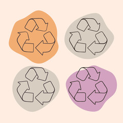 Four colored recycling symbols on pink background