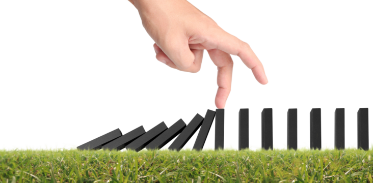 Hand stopping the Domino effect stopped by unique