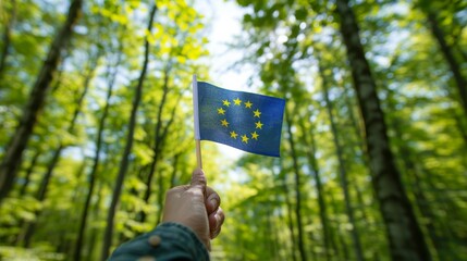 EU flag held by hand against a backdrop of lush, green forest under clear skies. Environmental consciousness with the EU flag in a lush, green forest setting.