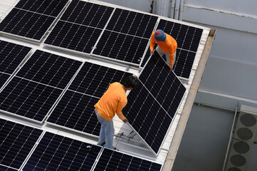 Worker installs solar panels. Worker installs solar panels at a solar farm field.
