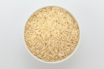 Organic White rice (Oryza sativa), in a white ceramic bowl. Isolated on a grey background. Top View