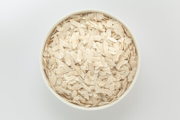 Organic Flattened rice (Oryza Sativa) or Poha in a white ceramic bowl. Isolated on a grey background. Top View