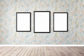 Three blank black picture frame mockups hanging on a floral wallpapered wall