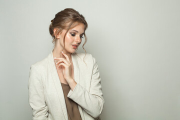 Pretty fashion model woman standing against white studio wall background