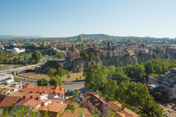 Landscape of old town Tbilisi with red roof on the background of blue sky