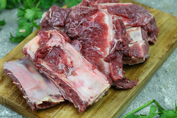 Iga sapi mentah or raw beef ribs  on preparation for cooking with some spice. Beef ribs on chopping board with wooden rustic background.
