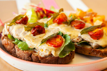 open-faced sandwich on multigrain bread. Topped with grilled chicken cherry tomatoes and honey mustard..